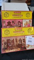 Two unopened Victorian Wood Furniture Dollhouse Kits boxes. One features a bedroom set with bed, night table, and dresser. The other is a dining room set. Both are Realife Miniatures Heritage Series.