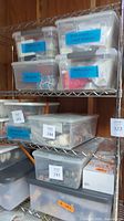 Metal wire shelving unit with multiple plastic storage bins and boxes on shelves, contents not included.