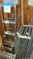 Stacked chrome wire shelves with horizontal bars and mesh surface.