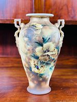 Front view of vase showing detailed hand-painted floral pattern and double handles.