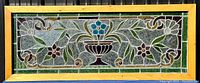 Front view of rectangular stained glass panel with central urn and floral design