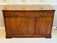 Front view of Georgian style mahogany sideboard buffet with drawer and three doors showing brass handles and wooden finish.