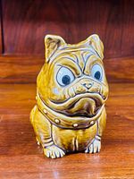 Front view of vintage English bulldog bank showing detailed facial features and studded collar.