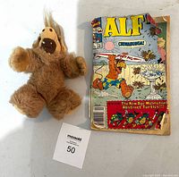 Photo showing the full plush ALF finger puppet next to the vintage ALF comic book with visible wear and tear.