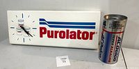 Full view of Purolator automotive clock and AC Delco collectible money bank side by side