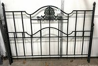 Full view of the black wrought iron king size headboard and footboard showing overall structure and style with vertical bars.