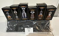 Photo showing six boxed miniature NHL trophies lined up side by side, labeled James Norris, Hart, Stanley Cup, Art Ross, Vezina, Conn Smythe, all original boxed packaging unopened.