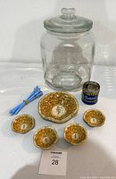 Large vintage Planters peanut glass jar, peanut motif ceramic bowls, vintage Planters peanut can, and blue swizzle sticks together