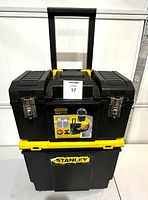 Front view of closed Stanley Rolling Workshop toolbox with extendable handle and metal latches, showing the label and brand sticker.