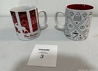 Two Tim Hortons coffee mugs side by side showing exterior designs.