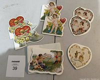 Photo showing six vintage-style Valentine cards with cherub and cupid designs along with matching envelopes on a white surface.