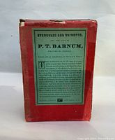 Front view of red slipcase with green label describing the autobiography and conditions of the books inside.