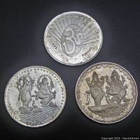 Three silver Indian coins and tokens; one side shows Hindu gods, other side features large Om symbol with rays and stars, with markings ".999" and "BOMBAY."