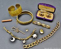 Full overview showing all jewelry including bracelets, pendants, locket, brooch, chain, and cuff links in box.