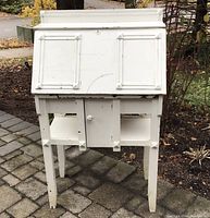Front view of painted oak drop-front desk with closed writing surface showing wear and chipped paint
