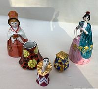 Five piece lot showing two figural covered boxes, two decorative shakers or holders, and one mini vase
