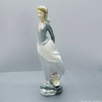 front three-quarter view of figurine showing windblown hair and skirt