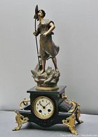 Front view of entire clock showing base, dial, feet, and sculpture