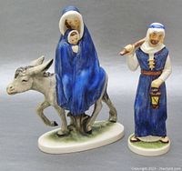 Front view of two figurines: Mary and baby Jesus on donkey and St. Joseph with lantern, showing detailed painting and color.