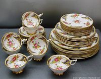 Full lot view showing stacked dinnerware and cups