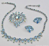 Full set arranged—brooch at center, earrings and necklace around