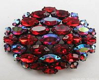Front view of domed brooch showing siam red and aurora borealis stones