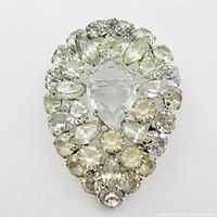 Front view of the brooch showing clear and light yellow rhinestones in a tear drop shape with a large clear open-backed crystal center.