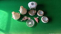Top-down view of all pieces on green felt, showing eight assorted trinket dishes and small vases.