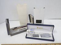 Two ballpoint pens in original packaging with ink cartridge and refill, displayed with open boxes.