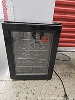 Closed Igloo FRW120 wine cooler showing black frame and glass door with red Igloo logo.