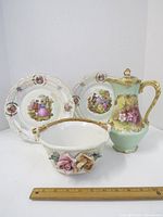 Full view of the four Limoges B & H French porcelain pieces including pitcher, two plates, and floral bowl