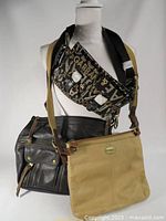 Photo showing all three handbags on display with Dolce & Gabbana crossbody bag at front, Fossil black leather shoulder bag and Fossil tan leather crossbody bag