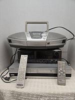 Full lot showing Panasonic boombox on top, Sony AV receiver and VHS player below with three remote controls in front.