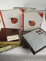 Photo showing 6 scrapbook/photo albums with some featuring decorative ladybug covers and one Recollections brand album with clear sleeves still packaged.