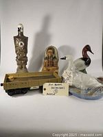 Full view of the 5 collectible decanters showing tiki totem, Native American figure, 2 ducks, and train car decanters.