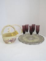 Set items placed on white surface showing 6 purple glasses, ceramic basket, and metal tray
