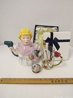 Full view of the three items: ceramic beautician teapot, Limoges trinket box, and decorative glass mug with gift box