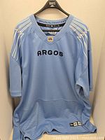 Full front view of light blue Toronto Argonauts jersey with ARGO lettering and CFL logo.