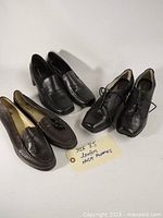 Three pairs of women's leather dress shoes including loafers with tassels, low-heel pumps, and lace-up oxfords arranged on a white background with a label showing size 8.5.