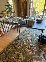Table with stacked plates, cups, and saucers showing table size and surface