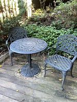 Three-piece outdoor wrought iron patio set with round table and two chairs
