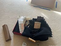 Top view of gloves, scarf, sunglasses, and boxed hand fans on carpeted floor.