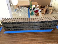 24 vintage hardcover Mark Twain books arranged in a row on a table, showing uniform green cloth covers with labels.