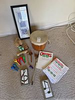 Image showing wooden drum, colorful shaker eggs, wooden shakers, drumsticks, Christmas song books, framed music-themed artwork, and two musical note bricks