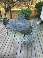 Overall view of round table and four chairs on wood deck