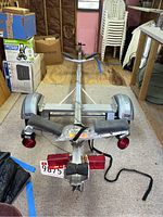 Front-to-rear view of entire aluminum boat trailer inside garage