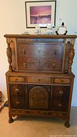 Front view of vintage wooden dresser with drawers and gold tone handles