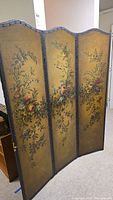 Full view of the four-panel vintage floral room divider, showing painted flowers on each panel.