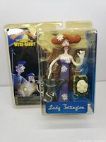 Front view of sealed Lady Tottington action figure in original packaging, showing figure and accessories inside blister pack.