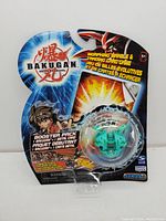 Front view of sealed 2007 Bakugan Battle Brawlers Series 1 booster pack with graphics and blue background, packaging intact.